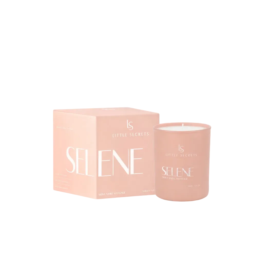 A pink skincare candle by Little Secrets in a frosted glass jar next to its matching pink packaging box, labeled 'SELENE SKINCARE MASSAGE'.