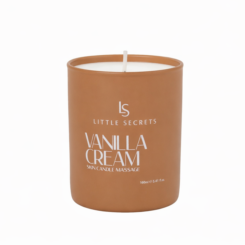 A Little Secrets Vanilla Cream skin candle in a matte terracotta-colored cylindrical jar with a white wick, shown on a clean white background.