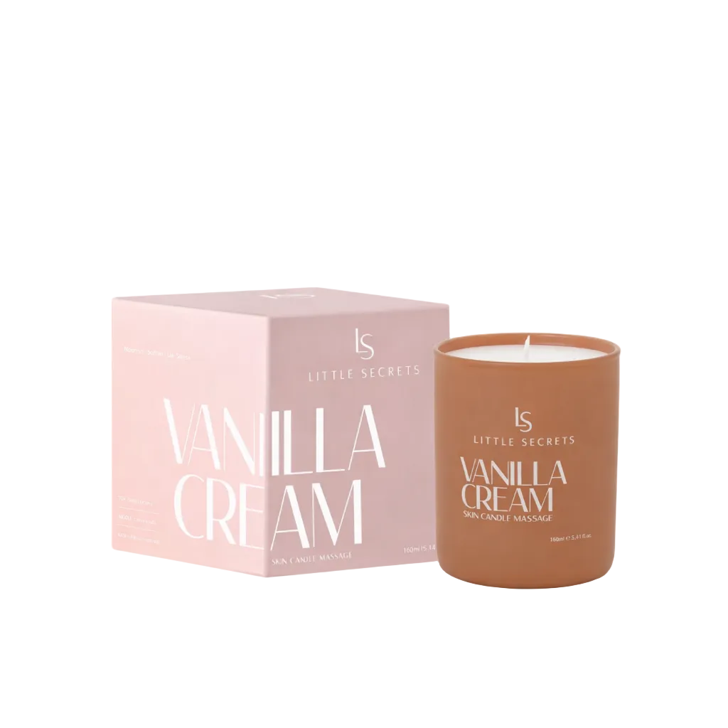 A Little Secrets Vanilla Cream skin candle massage in a terracotta-colored jar next to its light pink packaging box, on a white background.